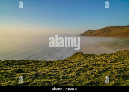 Banco di nebbia la laminazione in Rhossili Bay. Aprile 2015. Credito: Phillip Roberts Foto Stock