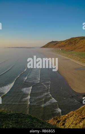 Banco di nebbia la laminazione in Rhossili Bay. Aprile 2015. Credito: Phillip Roberts Foto Stock