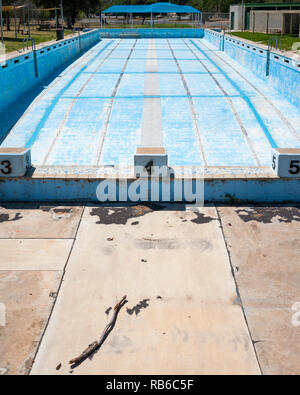 Vuoto sbiadito e piscina con stick in primo piano e area coperta in background, cittadina rurale Victoria Australia Foto Stock