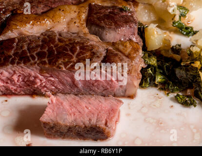 Grande occhio di nervatura bistecca su piastra bianca con cavolo e patate Foto Stock