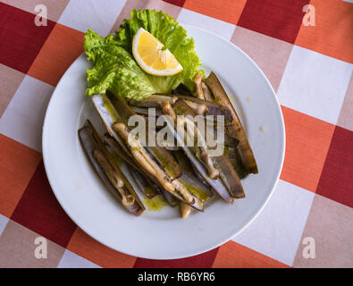 Una piastra di nitidezza delle vongole (navajas) servita in un ristorante a Combarro, Galizia, Spagna Foto Stock