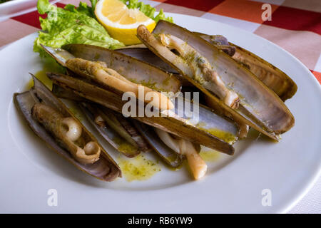 Una piastra di nitidezza delle vongole (navajas) servita in un ristorante a Combarro, Galizia, Spagna Foto Stock