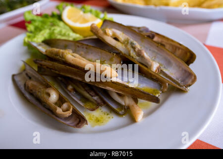 Una piastra di nitidezza delle vongole (navajas) servita in un ristorante a Combarro, Galizia, Spagna Foto Stock