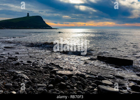 Fotografia paesaggio su Kimmeridge Bay beach su acqua ondulato che si affacciano sulla torre Clavell sotto cieli moody. Foto Stock