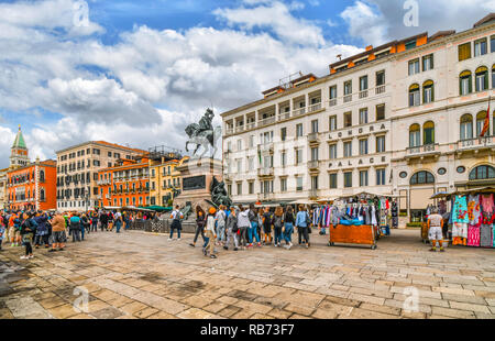 I turisti affollano le bancarelle del mercato vicino al Vittorio Emanuele statua sulla Riva degli Schiavoni sul Canal Grande vicino a Piazza San Marco Foto Stock