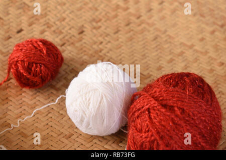 Bellissimo il bianco e il rosso rotondo sfera di filo isolato in sfondo marrone Foto Stock
