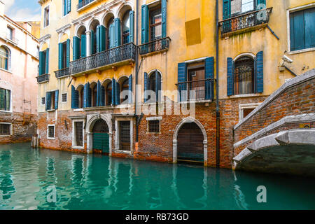 Un tipico e pittoresco e colorato Canal residenziale nel centro storico di Venezia, Italia con acqua verde smeraldo. Foto Stock