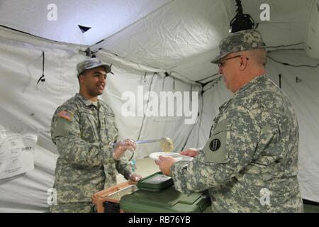 Spc. Wilfredo Colon, 942nd Transportation Company, serve la colazione, Sgt. Camere di Curtis, 459th Transportation Company, combustibili un generatore, durante un'operazione aerea, per la XIX annuale di Randy Oler Memorial il funzionamento del giocattolo Drop, ospitato dalla U.S. Esercito degli affari civili e le operazioni psicologiche il comando (airborne), a Luzon nella zona di caduta su dic. 12, 2016. Il funzionamento del giocattolo Drop è la più grande del mondo interforze e operazione di aerei e di formazione collettiva esercizio con otto partner-nazione paracadutisti che partecipano. Foto Stock