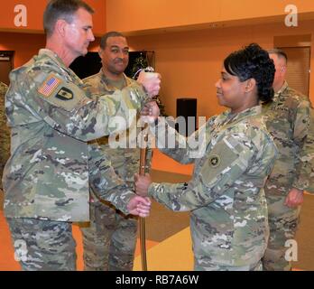 Col. Toni A. Glover, 650· Supporto regionale comandante del gruppo, passa il sottufficiale spada, che viene usato per indicare il trasferimento di responsabilità per il comando Sgt. Il Mag. Darin S. Daniels, una Mesa, Arizona, residente in un cambiamento di responsabilità cerimonia di George W. Dunaway esercito centro di riserva in Sloan, Nevada Dicembre 18. Nella sua capacità di civili, Daniels serve come un vigile del fuoco/personale paramedico sul Phoenix dei Vigili del Fuoco. Foto Stock