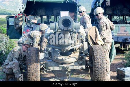 Stati Uniti Esercito artiglieri assegnato a una batteria, 4° Battaglione, 319Airborne campo reggimento di artiglieria, 173rd Brigata Aerea, pack di un M777 Obice come parte di esercitare la tempesta estiva 16 a Capo Teulada in Sardegna, Italia, Dicembre 2, 2016. Tempesta estiva 16 è una multinazionale di esercizio progettata per migliorare e costruire su una comprensione condivisa di vivere le operazioni antincendio, utilizzando sistemi di armi tattiche e procedure. Foto Stock