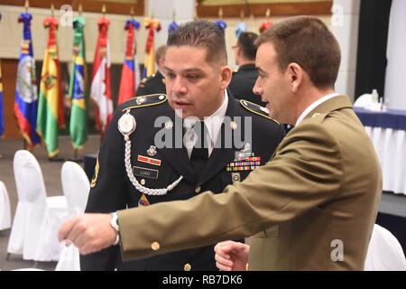 Sgt. 1. Classe Fredy Lugo dal permanente del Segretario Esecutivo della Conferenza degli eserciti americani parla con il Comandante Alberto Perez Monte dalla Spagna nel corso di una conferenza specializzata sui diritti dell'uomo. La Repubblica Dominicana esercito ha ospitato l'evento in Punta Cana il 2 dicembre, 2016. La conferenza ha lo scopo è stato quello di sviluppare una guida sulle norme e i principi dei diritti umani durante un aiuto in caso di catastrofe o di assistenza umanitaria missione dove le nazioni partner aiuterà il paese interessato. La Spagna è una nazione di osservatori della conferenza e non è un socio con diritto di voto. Foto Stock