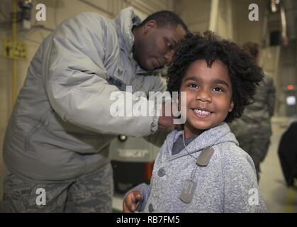 Stati Uniti Air Force Staff Sgt. Cameron Wilson, una sanità pubblica artigiano con la 182nd Medical Group, Illinois Air National Guard, luoghi personalized dog tag sul suo figlio al 182nd Airlift Wing annuali di festa Dec. 3 in Peoria, Ill. L'Peoria Vet Center dotato le dog tag di elementi unitari' bambini a parte. Foto Stock