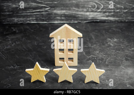 Tre stelle in legno e una casa. Albergo a tre stelle o ristorante. Recensione del critico. La qualità del servizio e il livello di servizio. Rating di case e pr Foto Stock