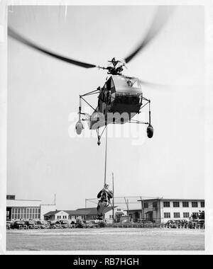 La Cmdr. Frank Erickson montacarichi Igor Sikorsky durante lo sviluppo del paranco in grado elicottero nei primi anni quaranta in Bridgeport, in Connecticut. Erickson è andato a volare molte missioni, salvare molte vite, treno molti piloti e ridefinire Coast Guard aviation. Foto Stock