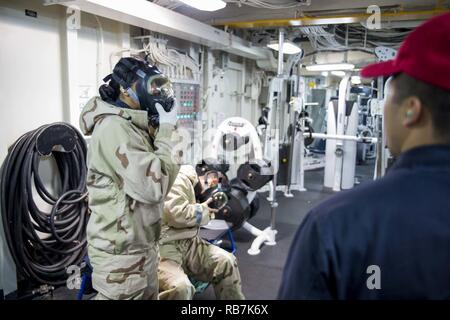 SASEBO, Giappone (dec. n. 6, 2016) Petty Officer di terza classe Laniece Watters (sinistra), da Columbus, Ohio, e sottufficiali di 2a classe di David Sacdal, da San Francisco, California, don MCU-2P di maschere antigas durante un chimico, biologico, radiologico praticare a bordo di assalto anfibio nave USS Bonhomme Richard (LHD 6). Bonhomme Richard, distribuita a Sasebo, Giappone, serve in avanti per fornire una rapida capacità di risposta in caso di emergenza regionale o calamità naturali. Foto Stock