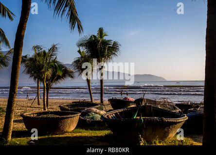 La mattina presto il sole sul round di barche da pesca che la Vietnames utilizzare. Questi sono parcheggiate nella sabbia Foto Stock