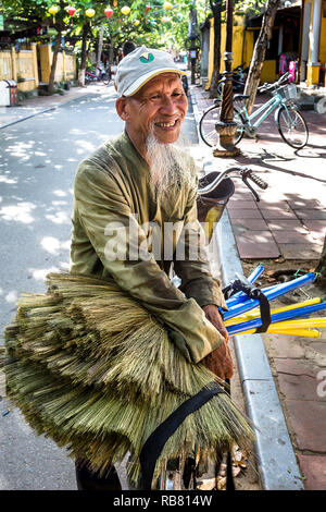 Il vecchio uomo vietnamita scope di vendita sulla strada. Foto Stock