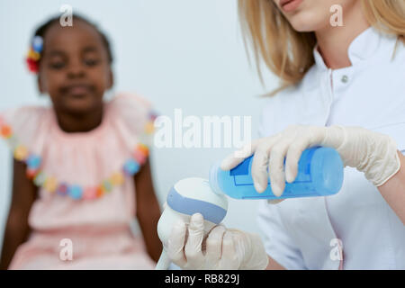 Primo piano vista del raccolto del medico azienda speciale attrezzatura medica e di preparazione per l'esame. Poco ragazza seduta e in attesa di consulenza professionale. Concetto di assistenza sanitaria. Foto Stock