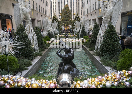 Guardando attraverso la banda degli Angeli in occasione dell'annuale albero di Natale al Rockefeller Center nel centro di Manhattan. È forse la più popolare destinazione turistica in NYC durante la stagione di festa di Natale. Foto Stock