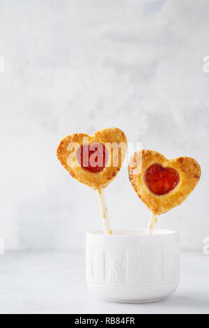 In casa biscotti frollini su un bastone. A forma di cuore ad dolci per il giorno di San Valentino. Foto Stock