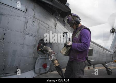Mare Mediterraneo (dec. n. 8, 2016) Il Marinaio Adam Rogers prende un campione di carburante prima del rifornimento di carburante un MH-60S Sea Hawk elicottero sul ponte di volo dell'assalto anfibio nave USS Wasp (LHD 1) 8 dicembre 2016. Wasp viene distribuito con la Vespa Anfibia gruppo pronto per supportare le operazioni di sicurezza marittima e di teatro la cooperazione in materia di sicurezza gli sforzi negli Stati Uniti Sesta flotta area di operazioni. Foto Stock