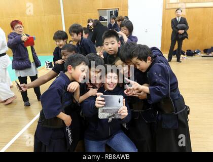 CAMP KENGUN, città di Kumamoto, Prefettura di Kumamoto, Giappone - privato di prima classe Kayla Melton, la polizia militare ufficiale con la 247MP DISTACCO, prende un selfie con i bambini della città di Kumamoto stazione di polizia Kendo dojo. I soldati hanno frequentato corsi di formazione di Kendo presso la città di Kumamoto stazione di polizia per promuovere buone relazioni tra i militari statunitensi e il popolo giapponese durante Yama Sakura 71. Esercizio Yama Sakura 71 è annualmente un posto di comando esercizio co-sponsorizzato da U.S. Pacifico esercito e il JGSDF a Camp Kengun da Dic. 1-13. Lo scopo di questo esercizio è di migliorare negli Stati Uniti e in Giappone il combattimento Foto Stock