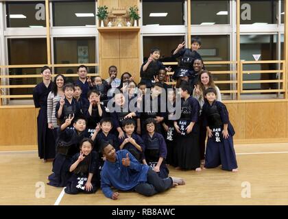 CAMP KENGUN, città di Kumamoto, Prefettura di Kumamoto, Giappone - Militari USA posano per una foto con i bambini della città di Kumamoto stazione di polizia Kendo dojo dopo formazione di Kendo e distribuendo spuntini e bevande. I soldati hanno frequentato corsi di formazione di Kendo presso la città di Kumamoto stazione di polizia per promuovere buone relazioni tra i militari statunitensi e il popolo giapponese durante Yama Sakura 71. Esercizio Yama Sakura 71 è annualmente un posto di comando esercizio co-sponsorizzato da U.S. Pacifico esercito e il JGSDF a Camp Kengun da Dic. 1-13. Lo scopo di questo esercizio è di migliorare gli Stati Uniti e il Giappone del combat readiness e mi Foto Stock