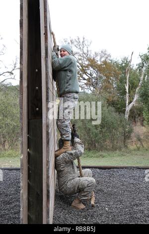 Spc. Victoria Lowery sorge sul suo marito della spalla, SPC. Il Ciad Lowery, di salire su una parete obsticle durante la fiducia di corso presso il primo custode sfida a Camp Bullis Dic. 9. Entrambi sono assegnati supporto toHeadquarters azienda, sede del Quartier Generale battaglione, U.S. Esercito Nord (Quinto esercito). Il concorso è stato progettato per la creazione di unità e coesione ESPRIT de Corps. Dodici squadre di due persone mettere le loro competenze al test come si sono mossi per ogni evento a piedi portando un 30-pound zaino. Le squadre hanno gareggiato in un esercito modificati Physical Fitness Test, corso di fiducia, armi qualifica r Foto Stock
