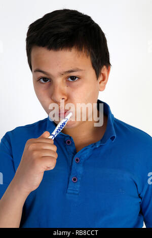 12-anno-vecchio ragazzo spazzolando i suoi denti. Foto Stock