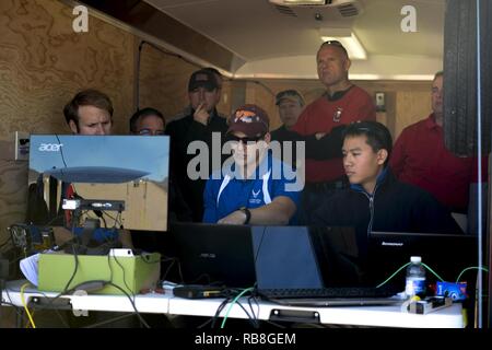 I membri del team di Robins Air Force Base, Ga., monitorare il loro contatore-Unmanned Aerial system come giudici osservare in background durante il 2016 Air Force Research Laboratory comandanti sfida al Nevada National Security Sito, Las Vegas NV., Dic 13, 2016. Le squadre hanno dato sei mesi per sviluppare una completa contro-Unmanned Aerial al sistema di aiuti in base defense. Robins' è un sistema multi-layered sistema integrato che utilizza un radar e sistema di telecamera per il rilevamento e l'identificazione. Esso utilizza anche un cacciatore killer drone di intercettazione e di un cannone ad acqua per sparare fuori del cielo. Foto Stock