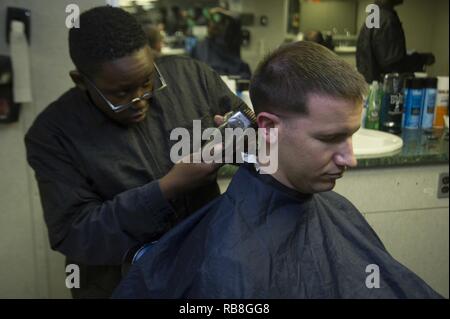 Mare Mediterraneo (dec. n. 13,2016) Petty Officer 1. Classe Fredrick Schmidt di Sanford, Fla. ottiene il suo taglio di capelli da marinaio Angelo Washington da Cocoa Beach, Florida in Barberia arruolato a bordo della portaerei USS Dwight D. Eisenhower CVN (69) (IKE). Ike, attualmente implementati come parte di Eisenhower Carrier Strike gruppo, sta conducendo operazioni navali negli Stati Uniti Sesta flotta area di operazioni a sostegno degli Stati Uniti per gli interessi di sicurezza nazionali in Europa. Foto Stock