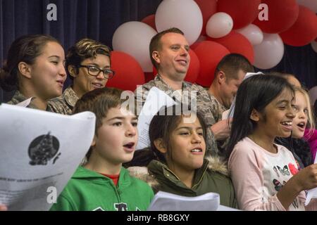 Tech. Sgt. Jane Hunter, sinistra e Senior Airman Lena Santiago, centro, sia con il 177th volo comunicazioni e Master Sgt. Benjamin Hemme, 177th squadrone di manutenzione, tutti con il New Jersey Air National Guard, pratica cantando canti di vacanze con il quarto livellatrici dal Seaview Scuola Elementare di Linwood, N.J., durante il XVI vacanza annuale "ongfest' presso il New Jersey Veterans Memorial Home a Vineland, N.J., Dic 13, 2016. Più di 80 quarta livellatrici e 18 aviatori cantato canzoni di vacanza e distribuite le carte per la casa residenti durante l'evento. Foto Stock