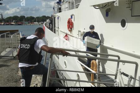 Coast Guard scaricati e trasferiti in custodia di tre sospetti di contrabbandieri e numerose balle di cocaina ALLA LEGGE FEDERALE DEGLI STATI UNITI alle autorità incaricate di far rispettare la legge in Santo Domingo, Repubblica Dominicana. In totale, circa 200 chilogrammi di cocaina per un valore stimato di valore all'ingrosso di $6.6 milioni di dollari è stato interdetto dic. 14, 2016 nel mar dei Caraibi come risultato multi-agenzia legge gli sforzi a sostegno dell'operazione Unified risolvere e funzionamento dei Caraibi di protezione. Foto Stock