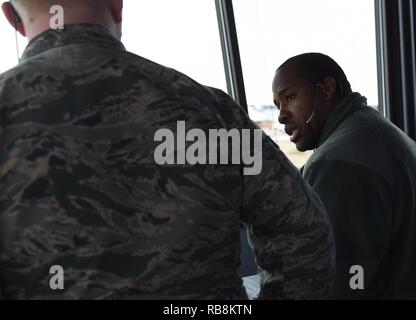 Stati Uniti Air Force Senior Airman Chino Ross, destra 1a supporto delle operazioni squadrone di controllore del traffico aereo, treni Senior Airman Patrick Taylor, 1° OSS controllore del traffico aereo, sul controllo del traffico aereo le pratiche di torre a base comune Langley-Eustis, Va., Dic 16, 2016. Patrick ha recentemente completato la formazione di aggiornamento per facilitare le operazioni di torre. Foto Stock