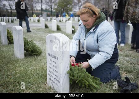 Joanne Trut, da Toms River, New Jersey, pone una corona di fiori su una lapide nella sezione 60 di Al Cimitero Nazionale di Arlington durante ghirlande in tutta l'America, Dic 17, 2016 in Arlington, Virginia ha detto, "Mio figlio fatto a casa, io sono qui per onorare coloro che non ha." Foto Stock