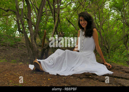 Giovane donna in abito bianco sorridente alla fotocamera, Pashan Tekdi, Sus Pashan Road, Pune, India Foto Stock