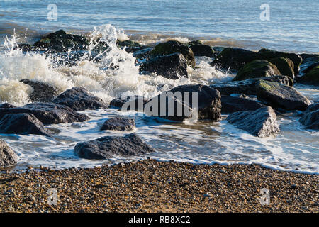 Surf rompe su roccia Clacton On Sea Essex England Regno Unito Foto Stock