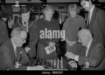 Il sindaco di Hastings e Audrey Callaghan guardare come Oliver Dawson (Presidente del Foreign & Colonial) gioca a scacchi contro il Signore Callaghan. Hastings 66internazionale annuale congresso scacchi. Inghilterra, Regno Unito, 1990 Foto Stock