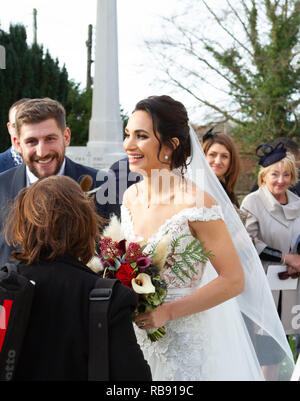 Il tradizionale matrimonio della soprano Laura Wright alla St Michael's Framlingham con il rugby Harry Rowland sembra felice e felice. Foto Stock