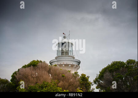 Sugarloaf Point lighthouse a Seal Rocks, Myall Lakes National Park, NSW, Australia. Faro sulla struttura collina coperta e grigio cielo cloud Foto Stock