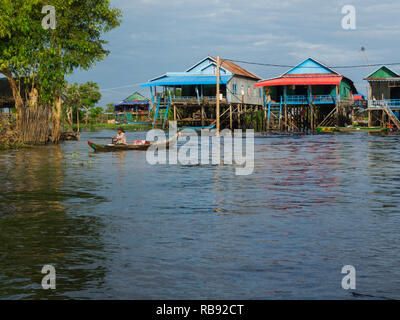 Abitante paddling canoe da casa in Kompong Phluk villaggio galleggiante di una comunità di circa 3000 principalmente la pesca Khmer abitanti Siem Reap Cambo Foto Stock