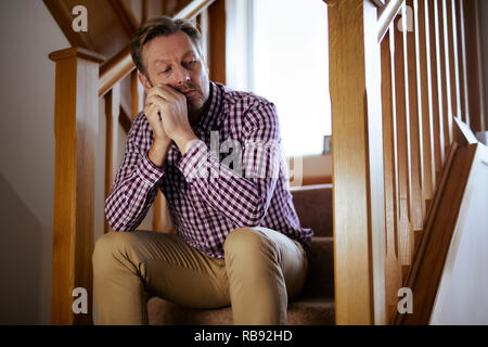 Uomo seduto sulle scale riflessivo Foto Stock