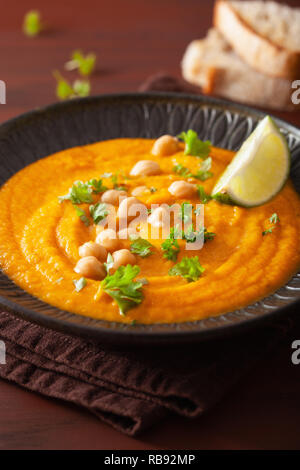 Carota cremosa zuppa di ceci su scuro dello sfondo rustico Foto Stock