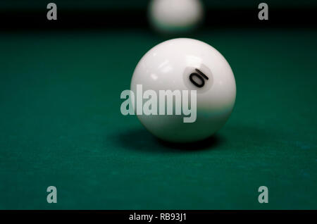 White palle da biliardo ricoperto su un tavolo con un panno verde. La sfera 10 Foto Stock