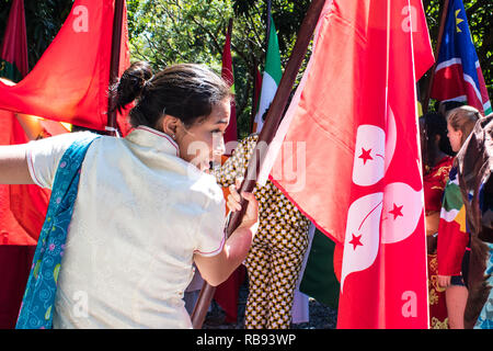 Una forte immagine di una ragazza di marching in esecuzione con una bandiera di Hong Kong Foto Stock