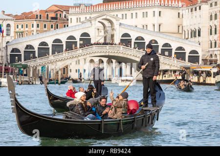 Venezia, Italia - 20 Marzo 2018: gondoliere veneziano in sella ai turisti in gondola al Canal Grande con il ponte di Rialto a sfondo Foto Stock