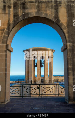 L assedio Bell Tower Memorial visti attraverso le arcate del Lower Barrakka Gardens, Valletta, Malta Foto Stock