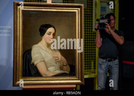 Berlino, Germania. 08 gen 2019. Un cameraman film l'immagine 'Ritratto di una giovane seduto donna/Portrait de jeune Femme assise' dall'artista Thomas Couture. Il dipinto del Gurlitt arte trovare è stato identificato come nazista di opere d'arte frutto di spoliazioni e restituito ai discendenti. Credito: Britta Pedersen/dpa-Zentralbild/dpa/Alamy Live News Foto Stock