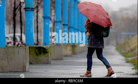 Berlino, Germania. 08 gen 2019. Una donna stessa protegge dalla pioggia con un ombrello. Credito: Britta Pedersen/dpa-Zentralbild/dpa/Alamy Live News Foto Stock