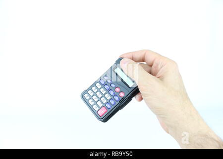 La mano destra di un uomo, detiene un oggetto comune, una calcolatrice Foto Stock